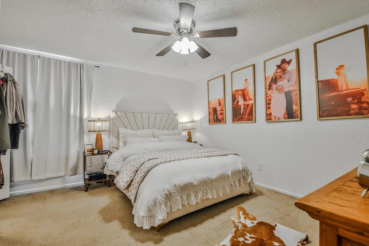 5708 3rd Street Lubbock, TX 79416 - Photo 12 of 23 a bedroom with a bed and a chandelier
