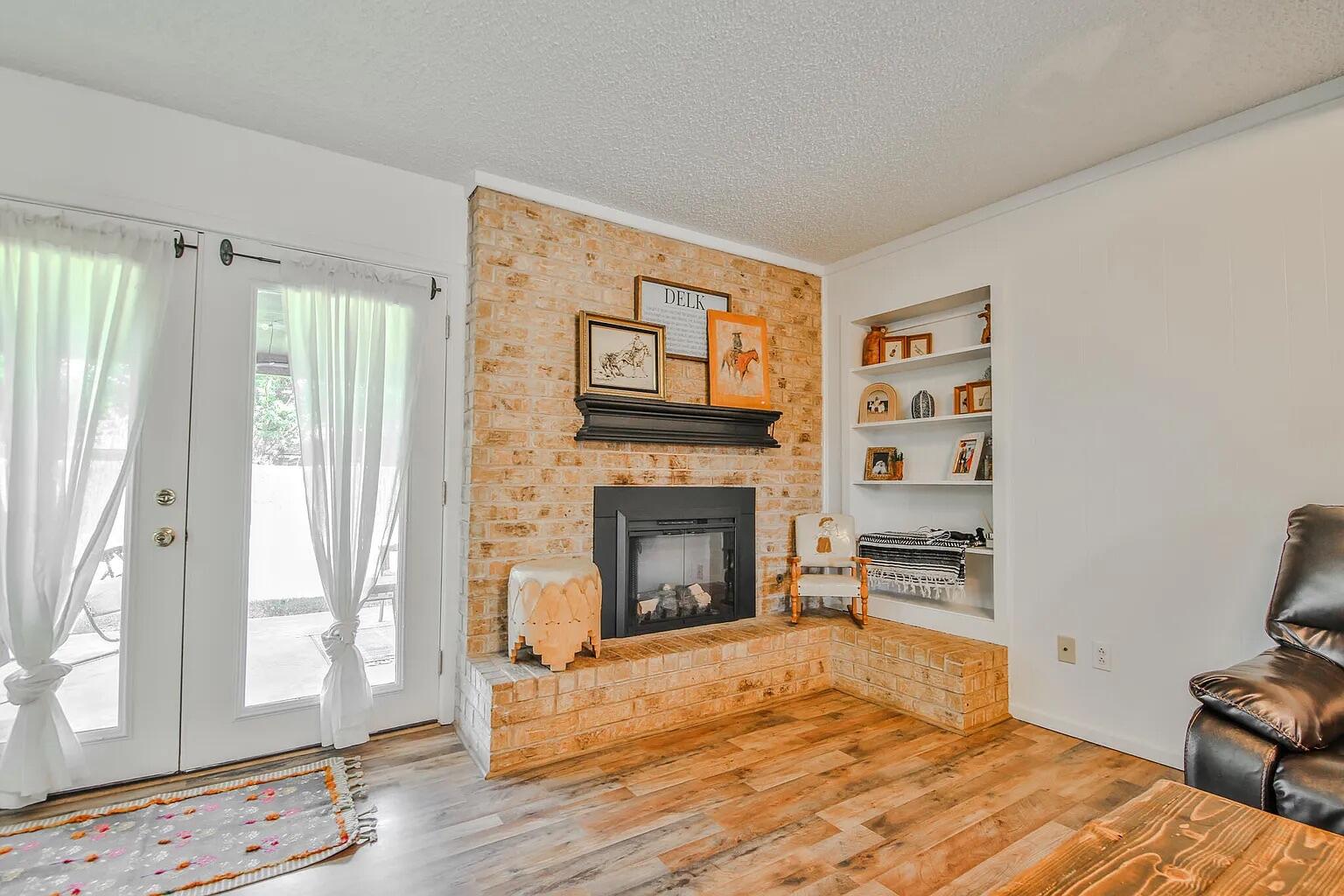 5708 3rd Street Lubbock, TX 79416 - Photo 19 of 23 a bedroom with furniture fireplace and wooden floor