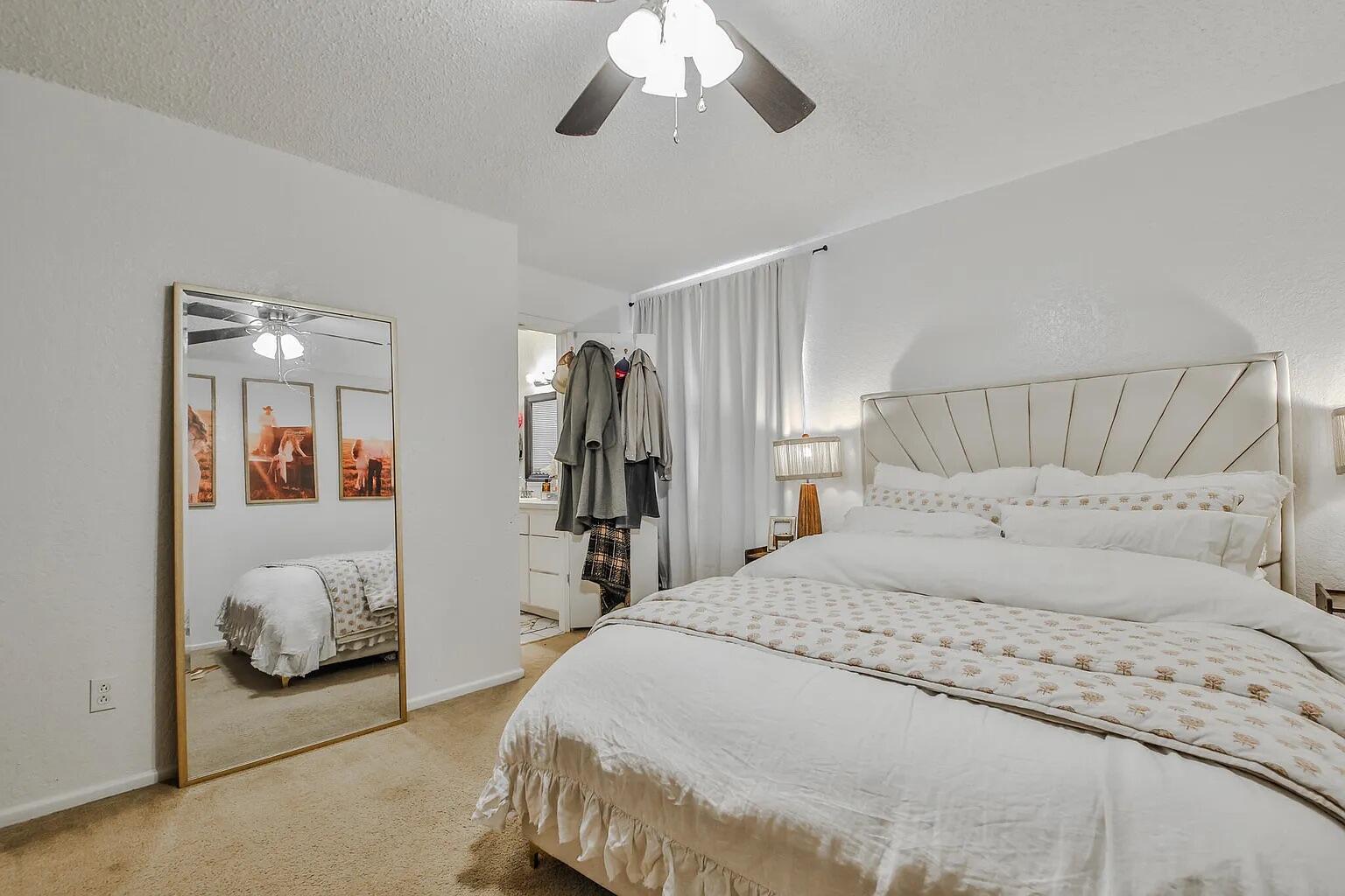 5708 3rd Street Lubbock, TX 79416 - Photo 22 of 23 a bedroom with a large bed and a large mirror