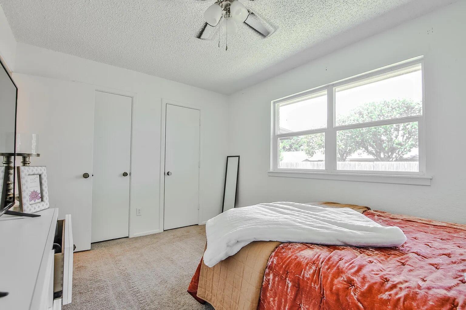5708 3rd Street Lubbock, TX 79416 - Photo 23 of 23 a bedroom with a bed and a chandelier