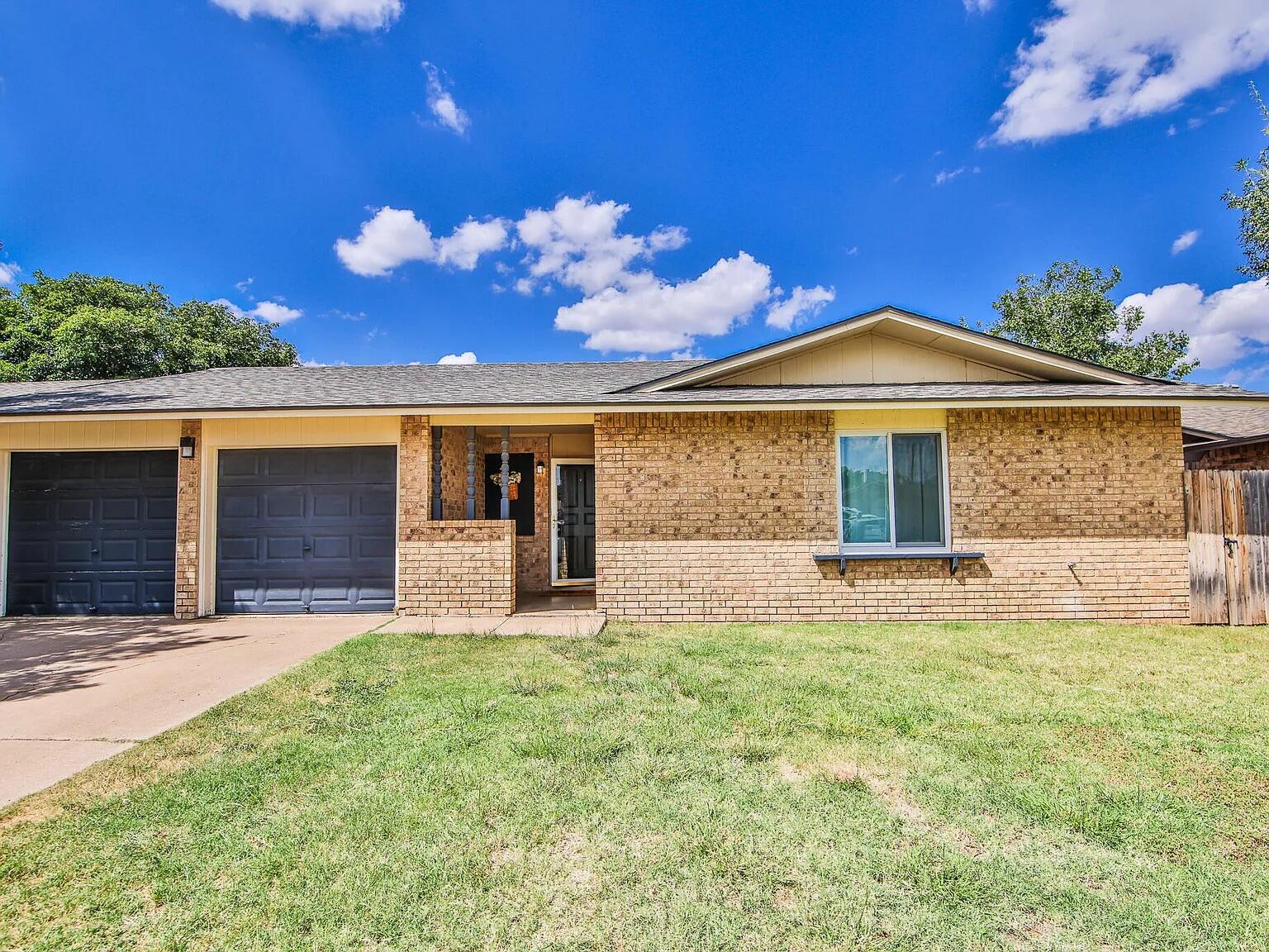 5708 3rd Street Lubbock, TX 79416 - Photo 10 of 23 a view of a house with a yard and a garage