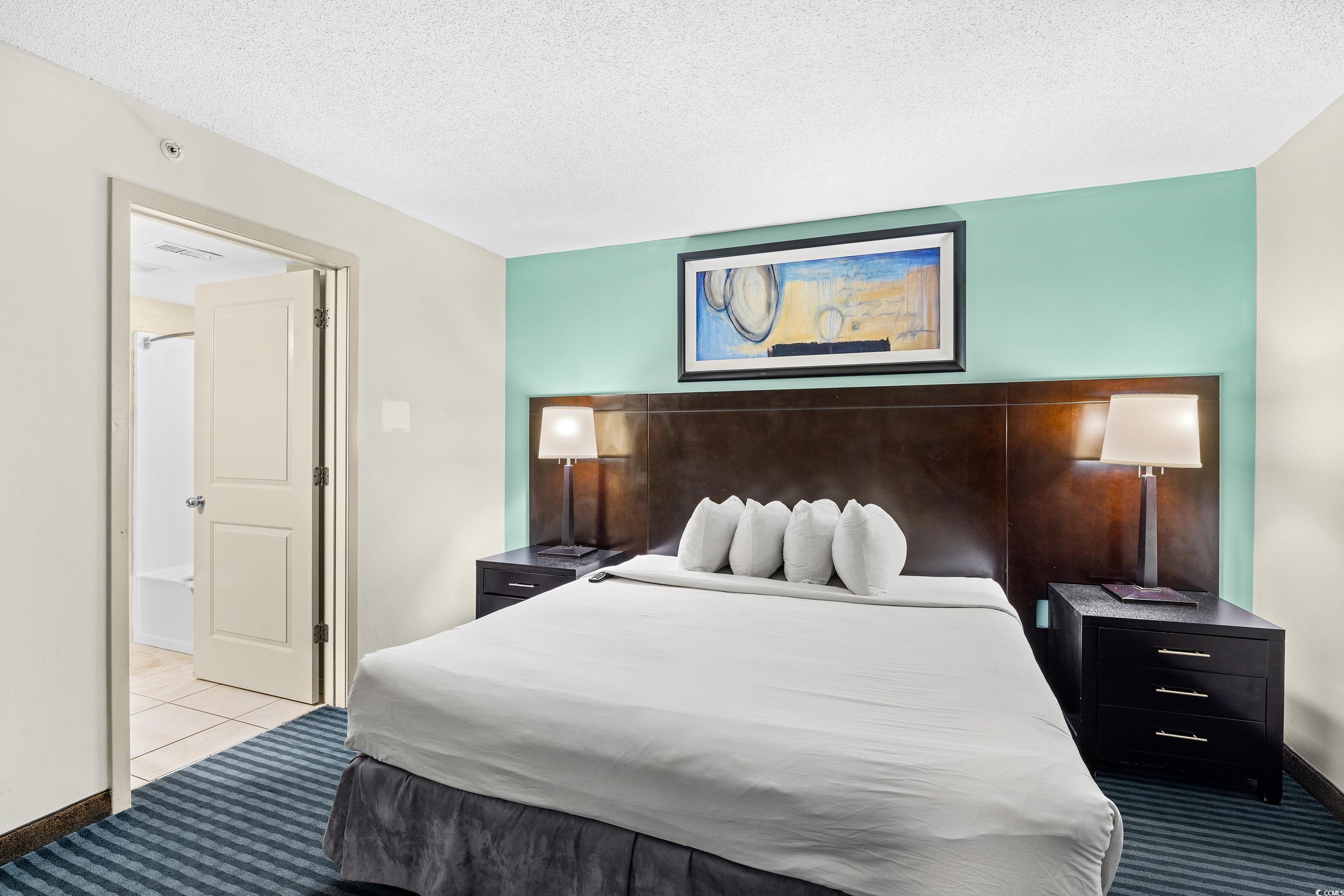 107 Ocean Boulevard, Unit 1402 Myrtle Beach, SC 29577 - Photo 11 of 38 Carpeted bedroom with visible vents and a textured ceiling