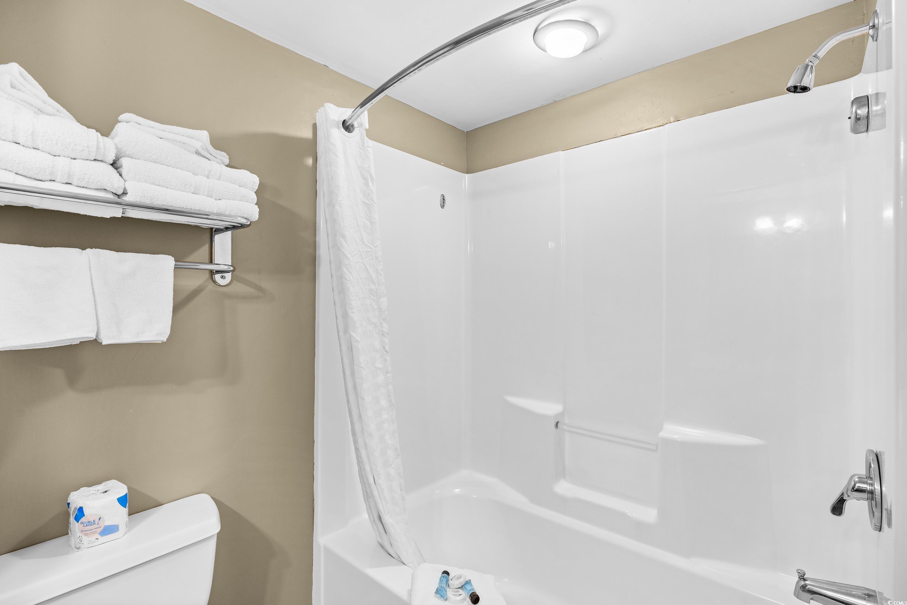 107 Ocean Boulevard, Unit 1402 Myrtle Beach, SC 29577 - Photo 13 of 38 Bathroom featuring toilet and shower / bathtub combination with curtain