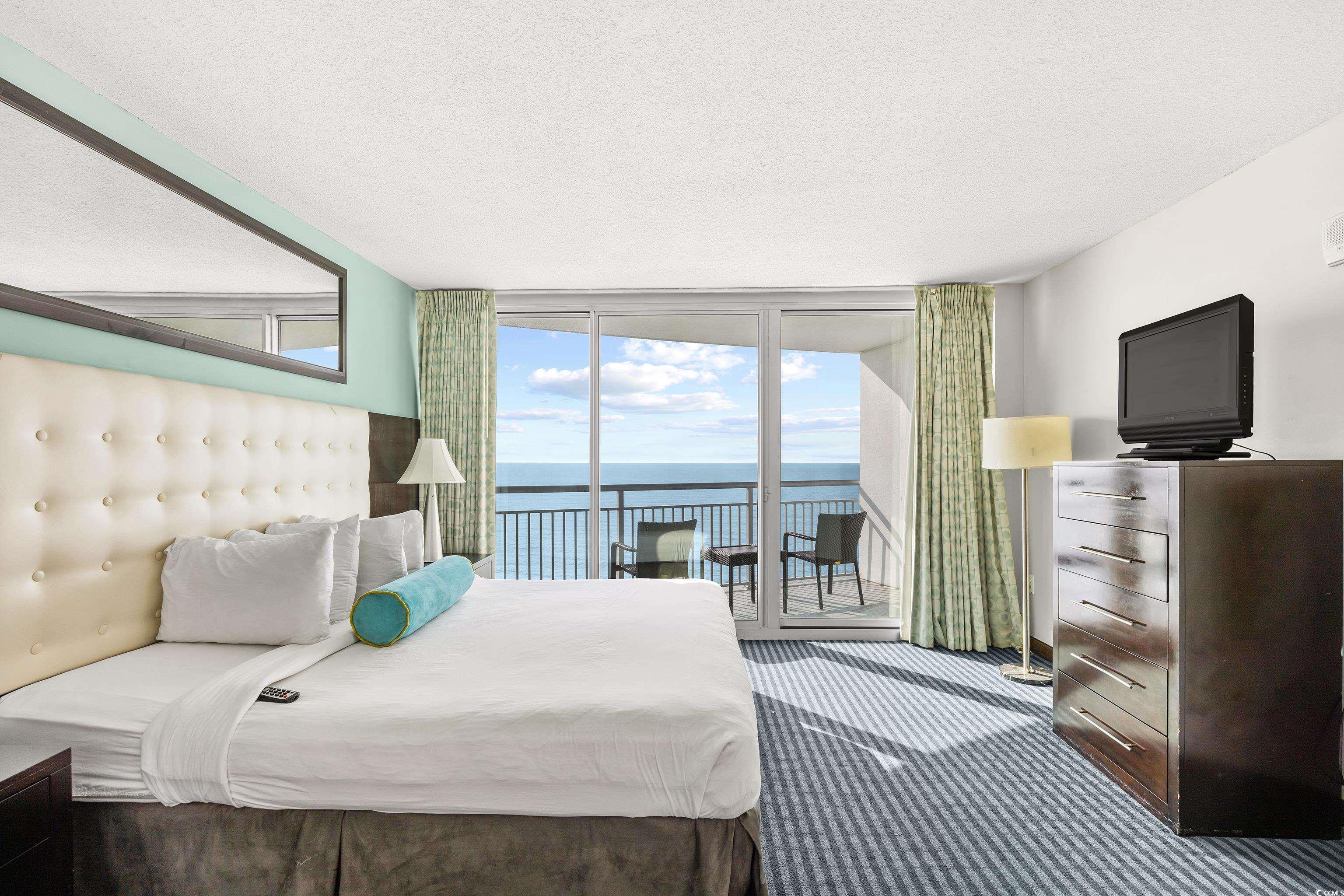 107 Ocean Boulevard, Unit 1402 Myrtle Beach, SC 29577 - Photo 20 of 38 Carpeted bedroom featuring expansive windows, baseboards, access to exterior, and a textured ceiling