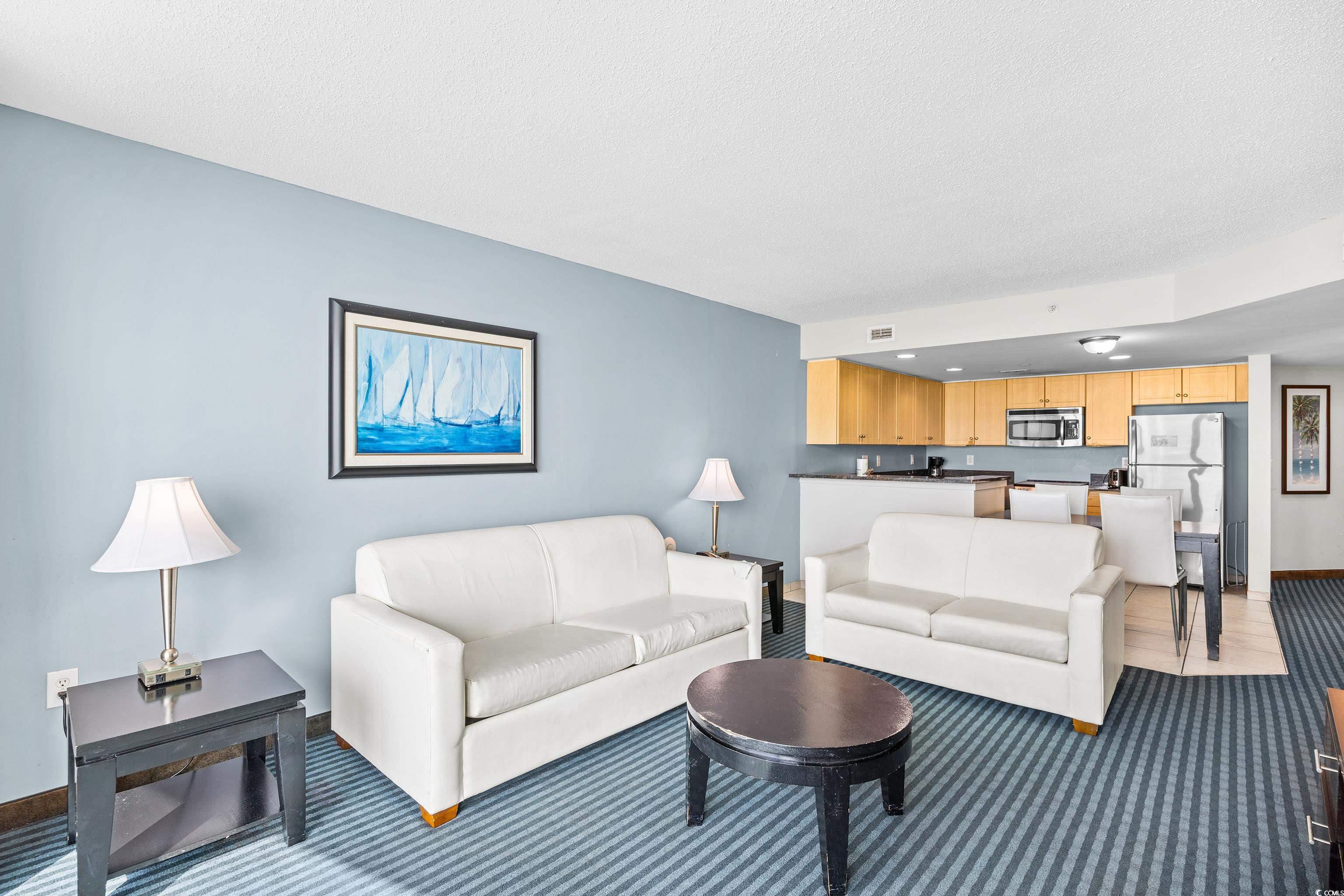 107 Ocean Boulevard, Unit 1402 Myrtle Beach, SC 29577 - Photo 6 of 38 Living area featuring light carpet and baseboards
