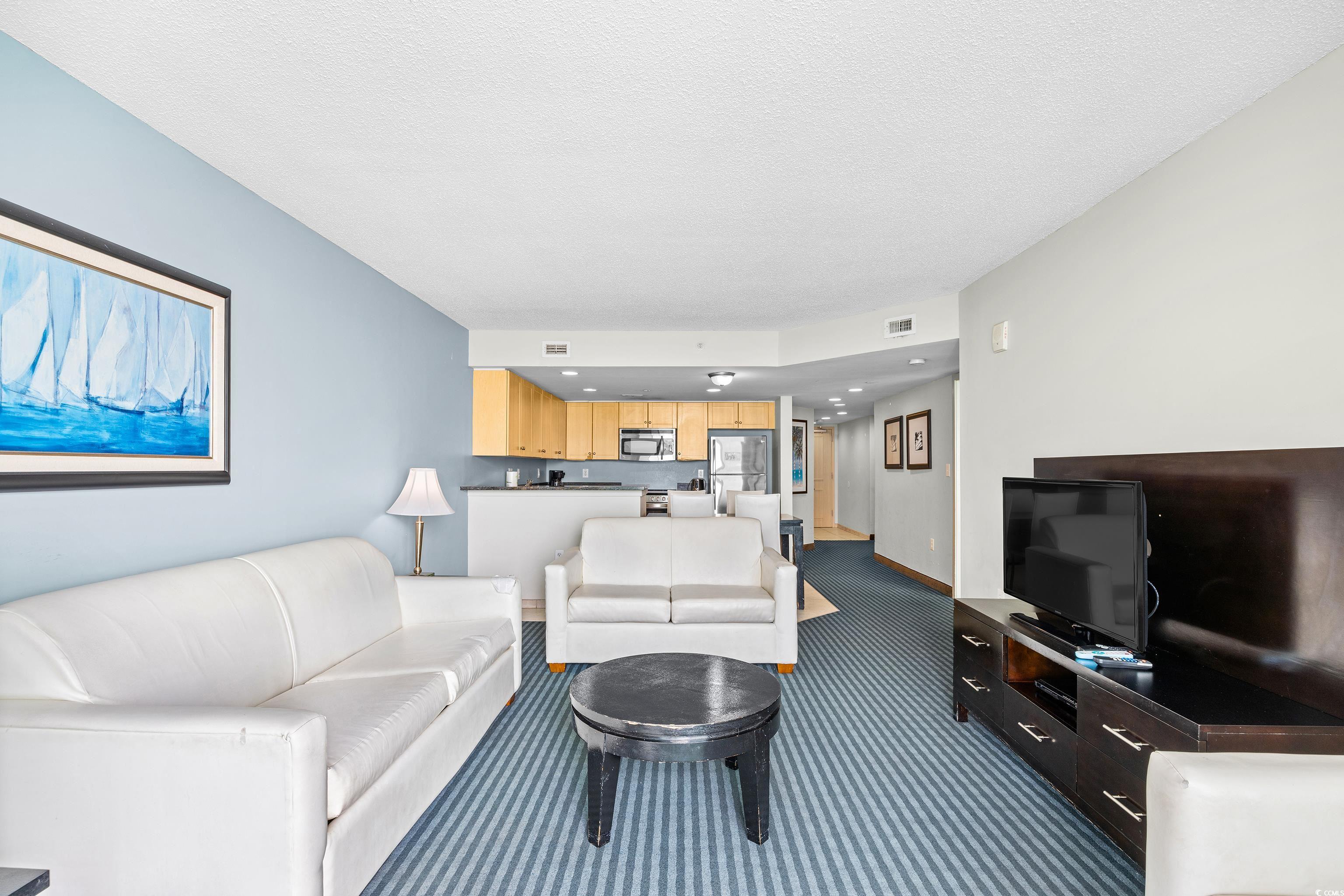 107 Ocean Boulevard, Unit 1402 Myrtle Beach, SC 29577 - Photo 10 of 38 Living area featuring a textured ceiling, carpet floors, and visible vents