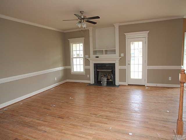 1405 Silver Farm Road Raleigh, NC 27603 - Photo 3 of 12 wooden floor fireplace and windows in an empty room