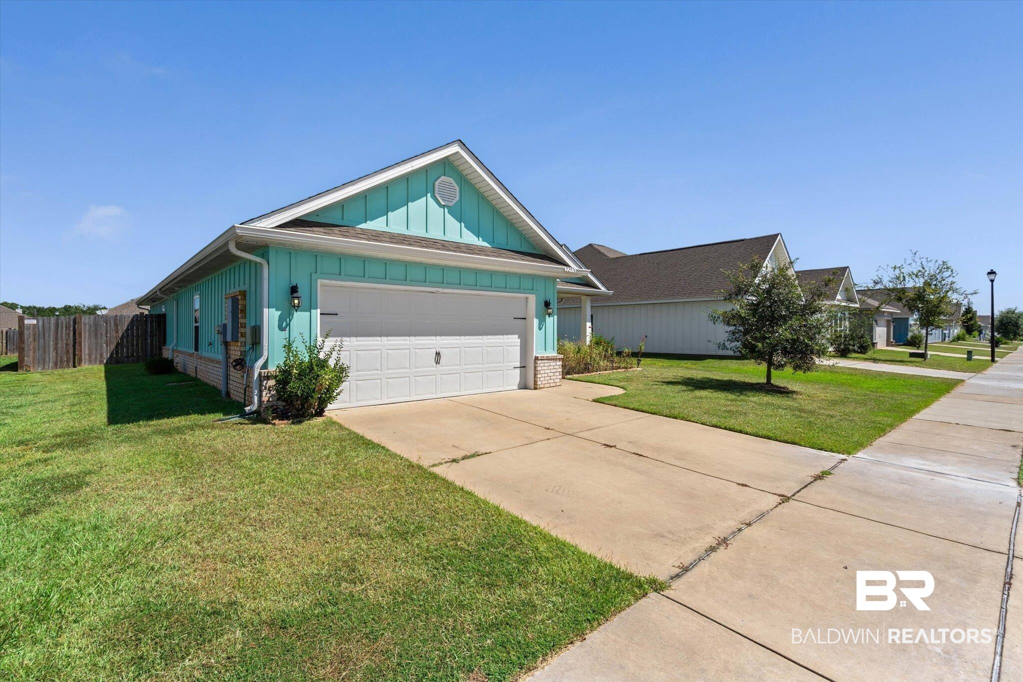 22976 Lieutenant Avenue Foley, AL 36535 - Photo 4 of 30 View of front of house featuring board and batten siding, driveway, a garage, and brick siding