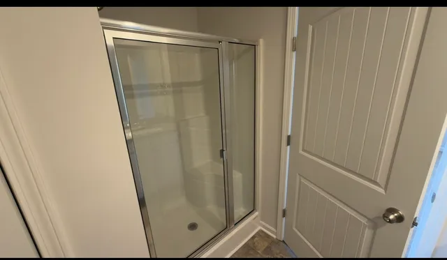 a bathroom with a glass door shower and vanity