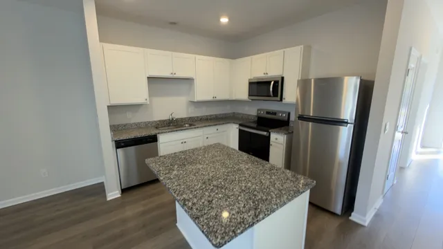 a kitchen with stainless steel appliances granite countertop a refrigerator stove microwave and sink