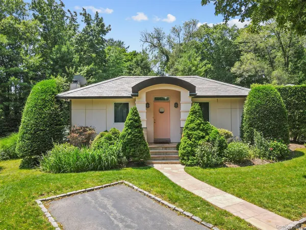 a front view of a house with a yard and fountain