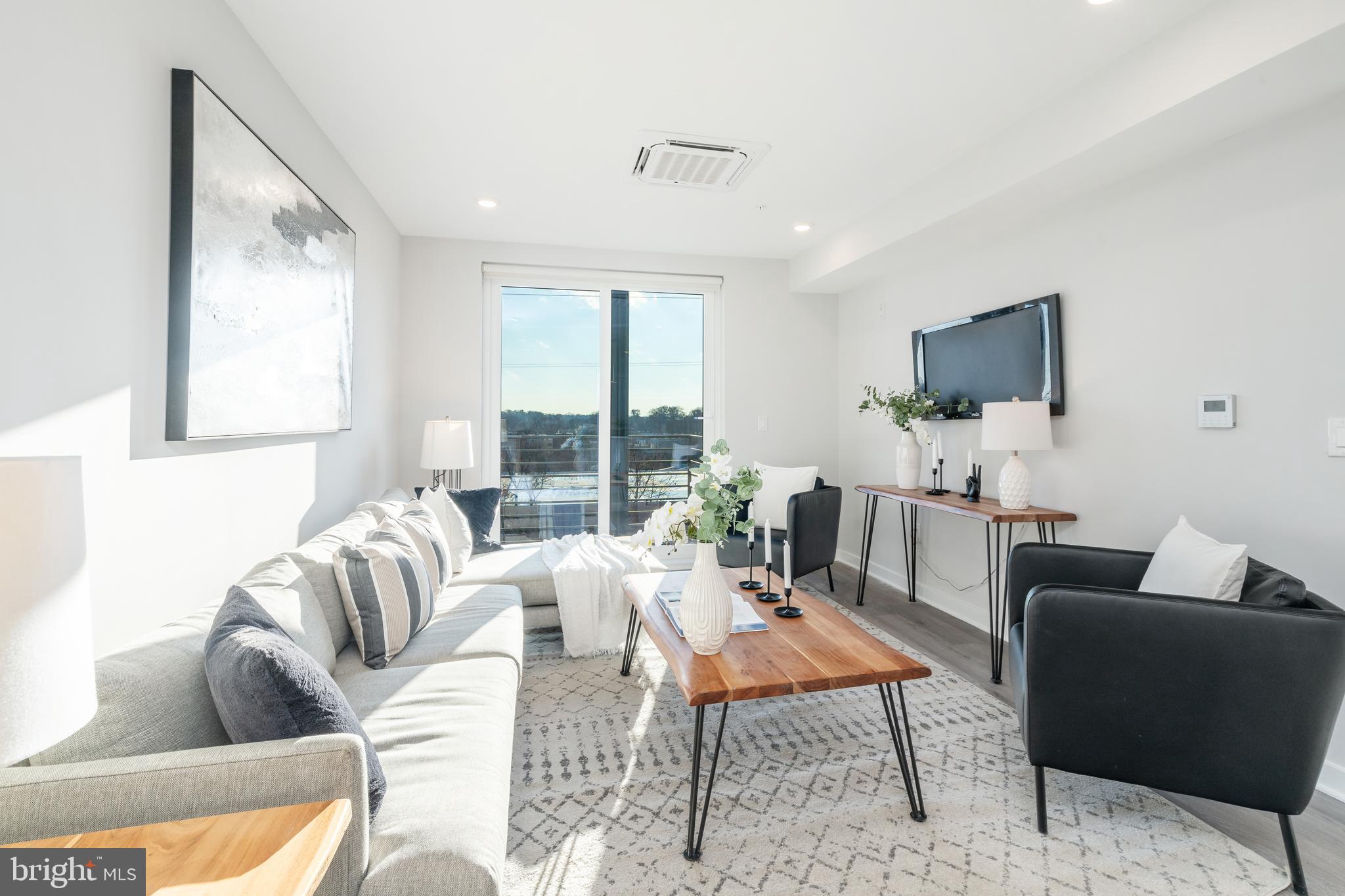 3449 Scotts Lane, Unit B413 Philadelphia, PA 19129 - Photo 3 of 17 a living room with furniture and a flat screen tv