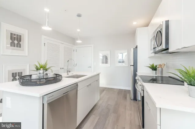 a kitchen with stainless steel appliances sink and white cabinets