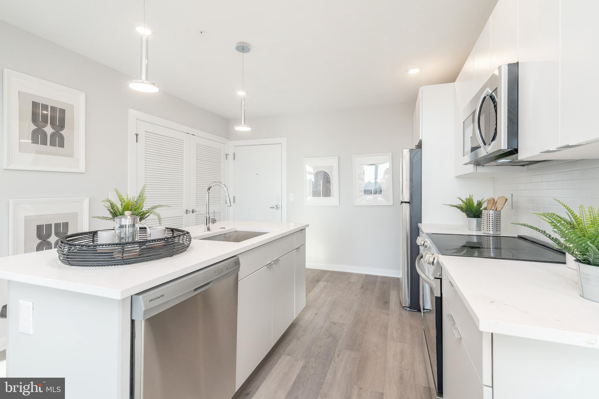 3449 Scotts Lane, Unit B413 Philadelphia, PA 19129 - Photo 7 of 17 a kitchen with stainless steel appliances sink and white cabinets