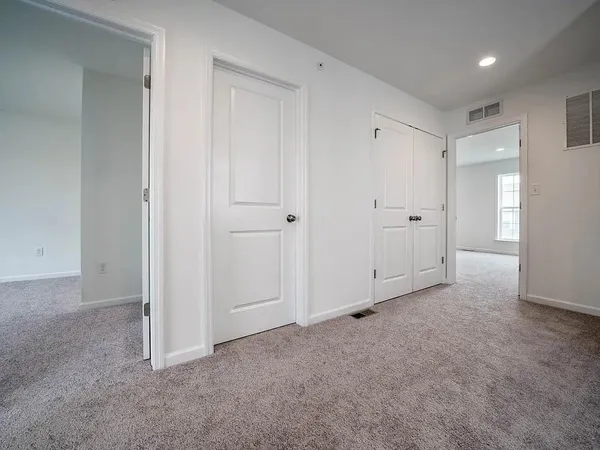an empty room with wooden floor and entryway