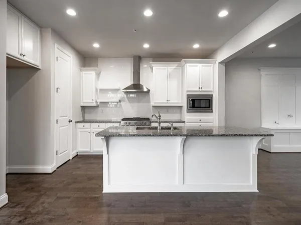 a large kitchen with stainless steel appliances granite countertop a stove a sink and a microwave