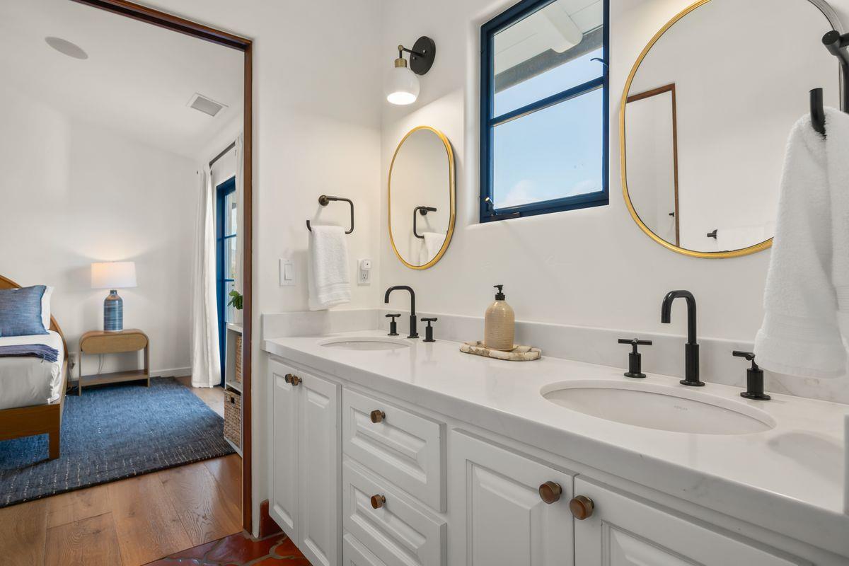 13202 Ojai Road Santa Paula, CA 93060 - Photo 34 of 50 a en suite bathroom with a granite countertop sink and a mirror