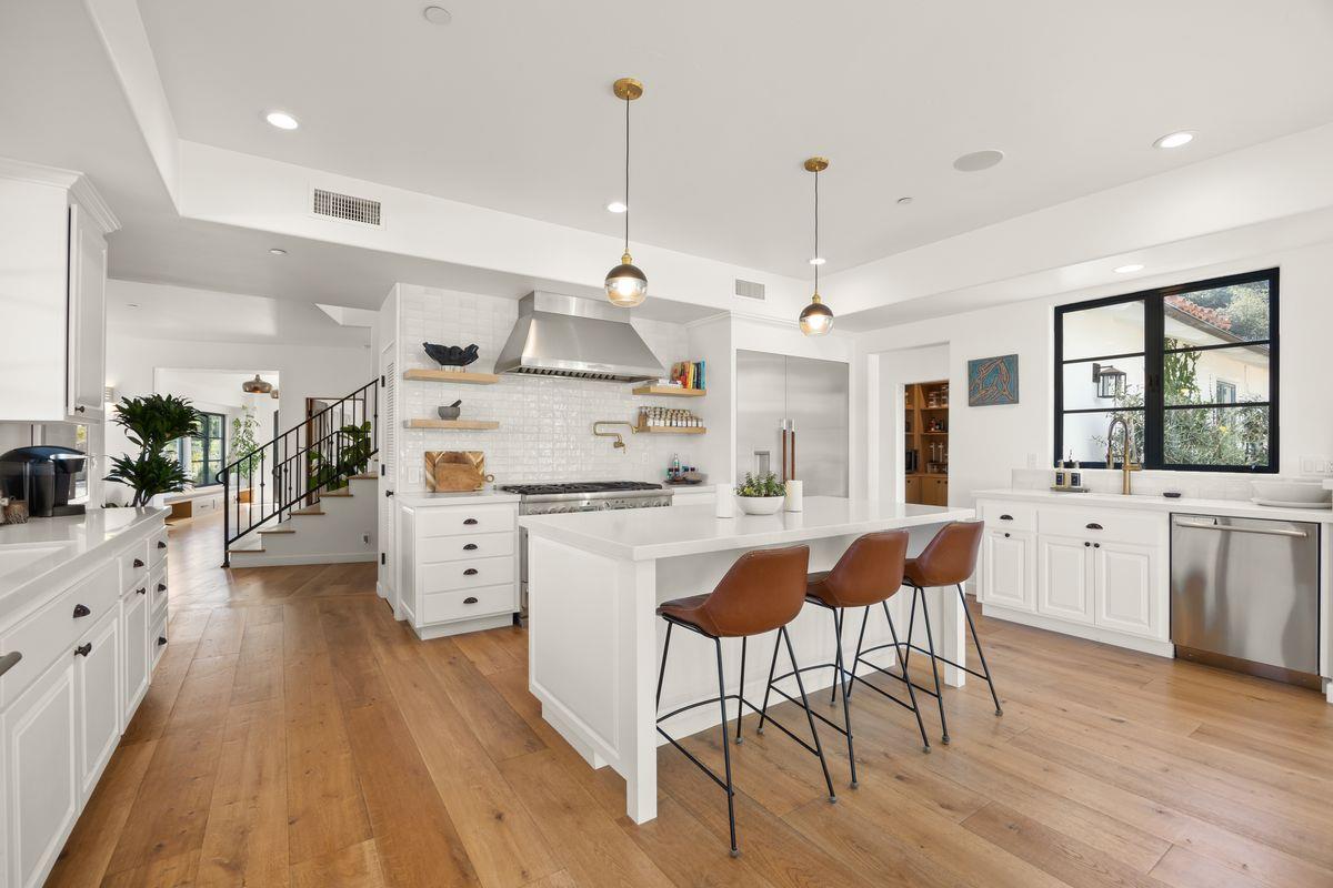 13202 Ojai Road Santa Paula, CA 93060 - Photo 10 of 50 a kitchen with stainless steel appliances kitchen island granite countertop a stove a sink dishwasher and a dining table with wooden floor