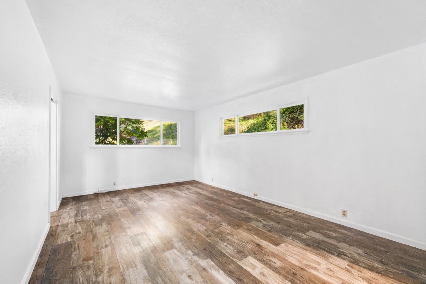 1000 Harmon Gulch Road Boulder Creek, CA 95006 - Photo 12 of 44 an empty room with wooden floor and windows