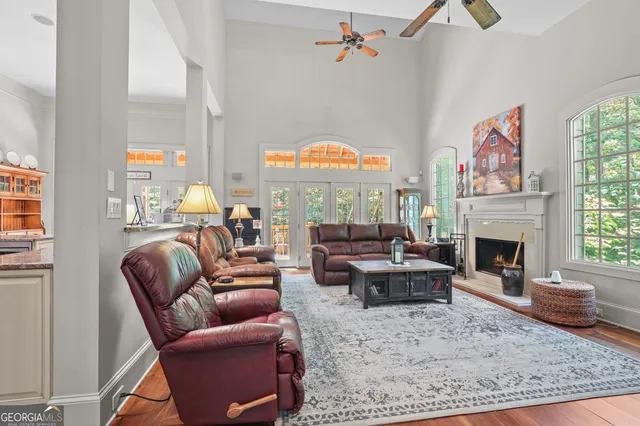 a kitchen with stainless steel appliances granite countertop a stove a sink dishwasher and white cabinets with wooden floor