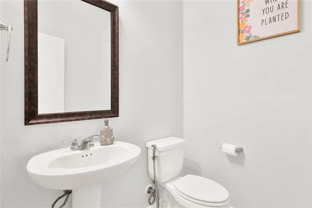 a bathroom with a toilet sink and mirror