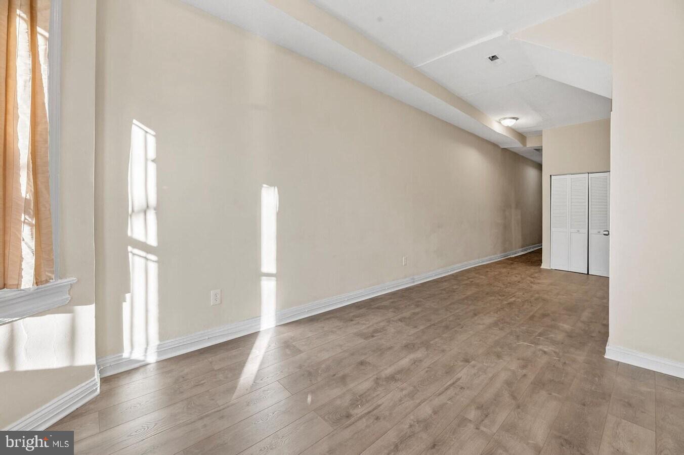 1821 North Capitol Street Northeast, Unit 2 Washington, DC 20002 - Photo 5 of 10 a view of an empty room with wooden floor and a window