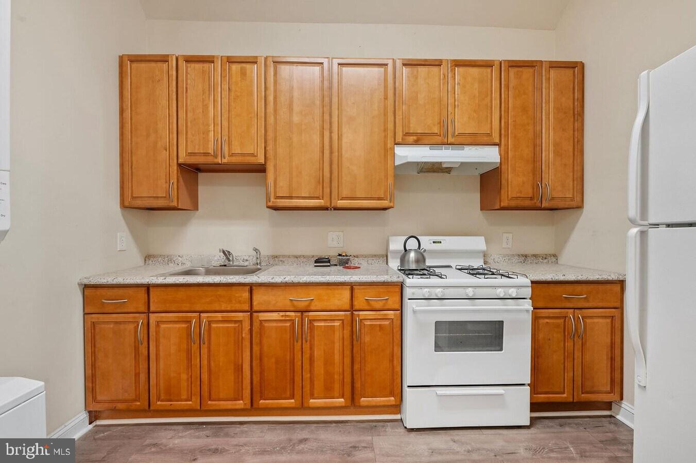 1821 North Capitol Street Northeast, Unit 2 Washington, DC 20002 - Photo 7 of 10 a kitchen with wooden cabinets and white appliances
