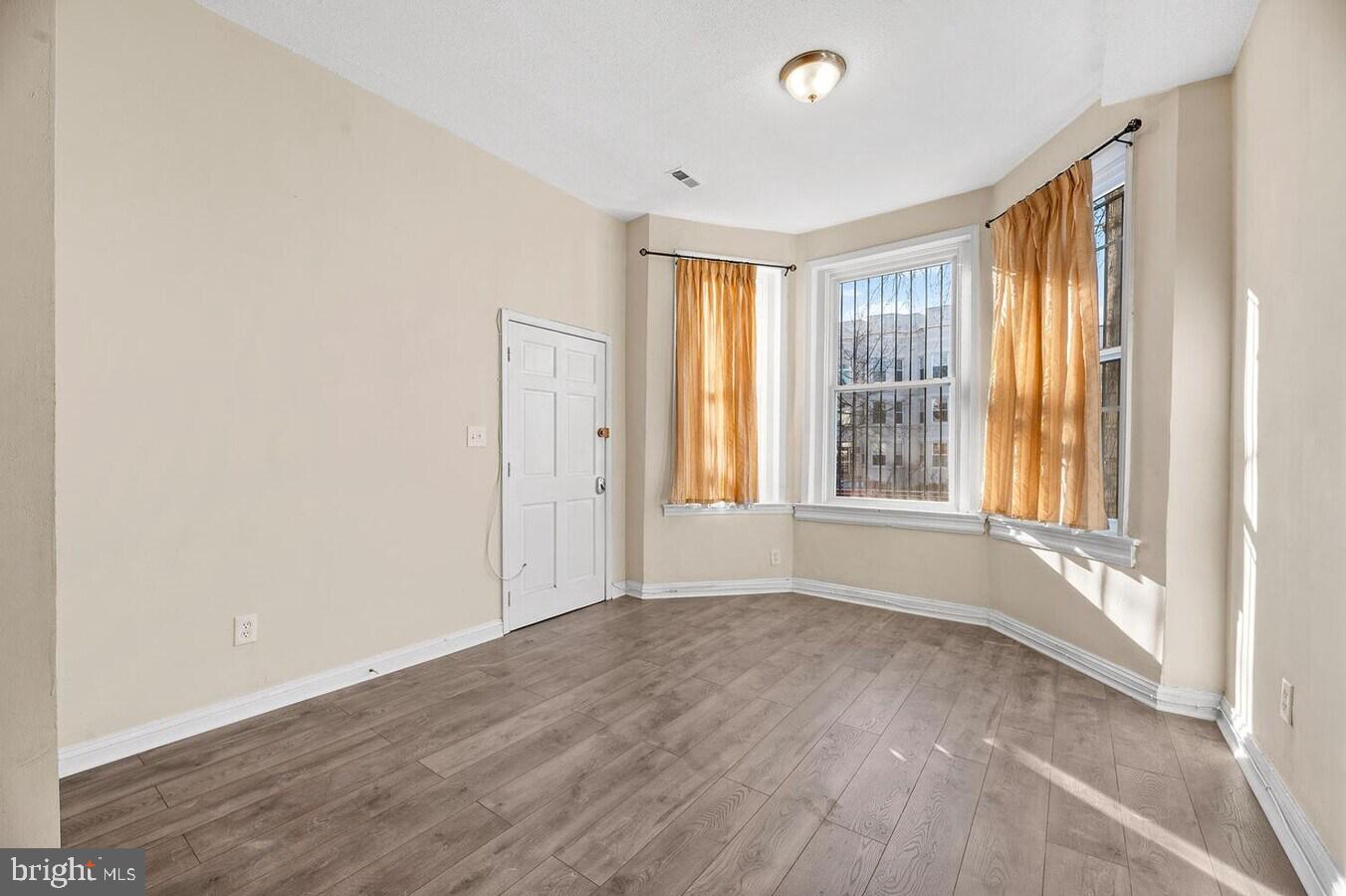 1821 North Capitol Street Northeast, Unit 2 Washington, DC 20002 - Photo 9 of 10 a view of an empty room with wooden floor and a window