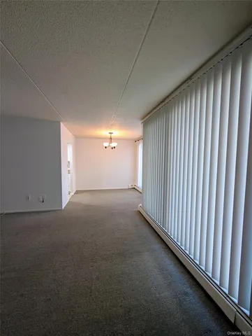 a view of a livingroom with an empty space and floor to ceiling window