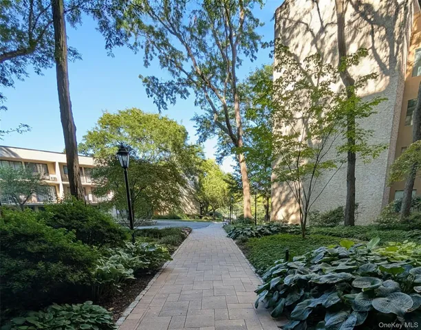 a front view of a house with a yard and fountain in middle