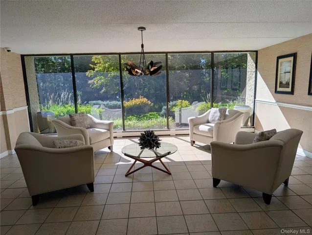 a living room with furniture and a floor to ceiling window