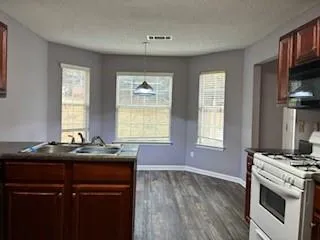 a kitchen with a sink stove and cabinets