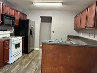 a kitchen with stainless steel appliances granite countertop a stove a refrigerator and a microwave