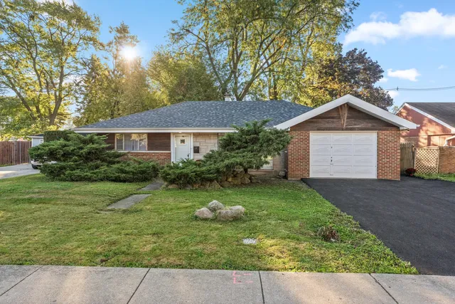 a front view of a house with a yard and trees