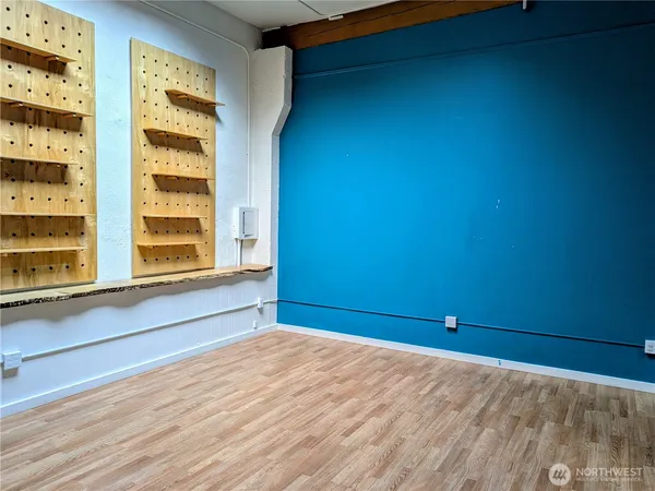 a view of empty room with window and wooden floor