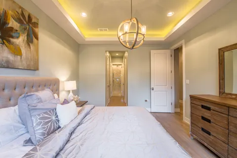 a spacious bedroom with a bed and a chandelier