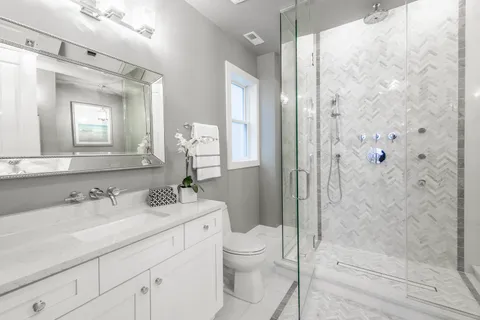 a bathroom with a sink a toilet and shower