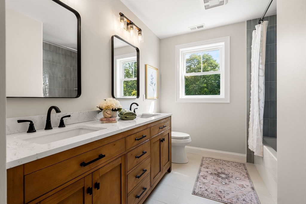 61 Mt Pleasant Street Woburn, MA 01801 - Photo 26 of 39 a bathroom with a double vanity sink toilet and a mirror