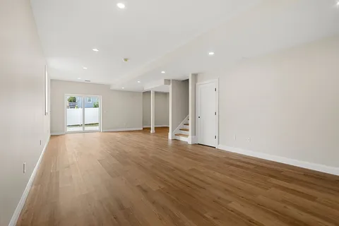 a view of empty room with wooden floor and window