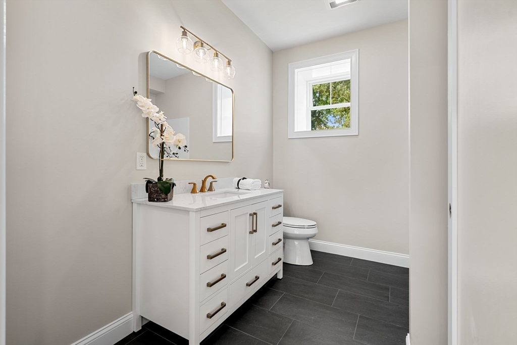 61 Mt Pleasant Street Woburn, MA 01801 - Photo 34 of 39 a bathroom with a double vanity sink and mirror
