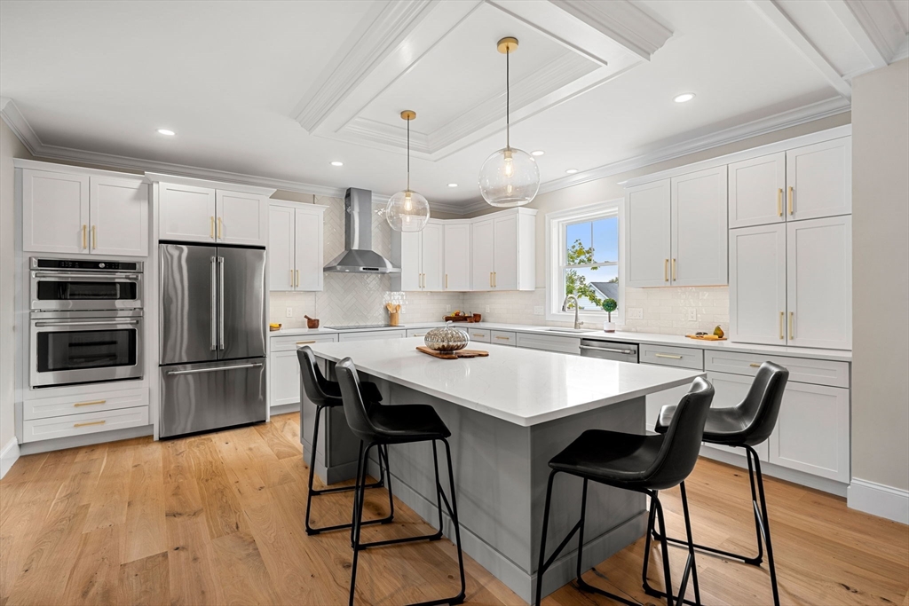 61 Mt Pleasant Street Woburn, MA 01801 - Photo 7 of 39 a kitchen with kitchen island a dining table and chairs