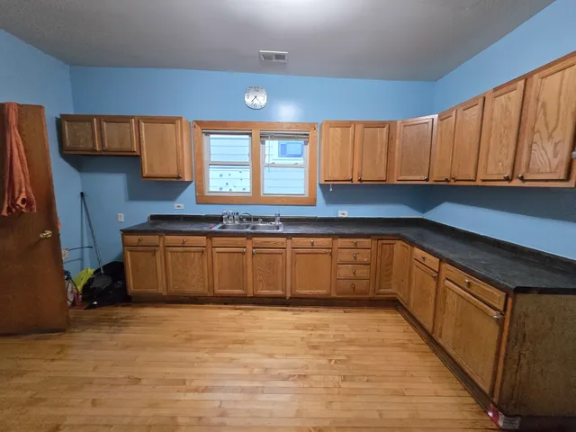 a kitchen with granite countertop a stove a sink and a refrigerator