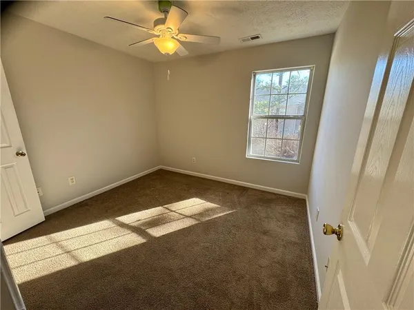 an empty room with a chandelier fan