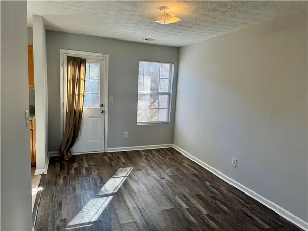 an empty room with wooden floor and a window