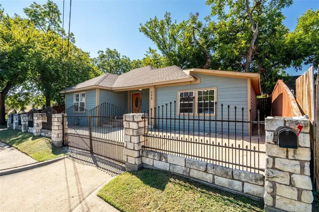 a view of a house with a small yard and wooden fence
