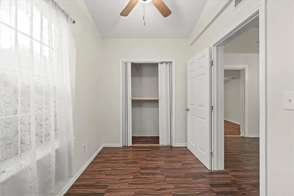 a view of a hallway with wooden floor and closet