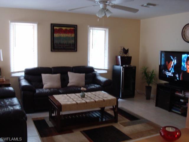 1205 Creech Road Naples, FL 34103 - Photo 4 of 10 a living room with furniture a flat screen tv and a wall paintings