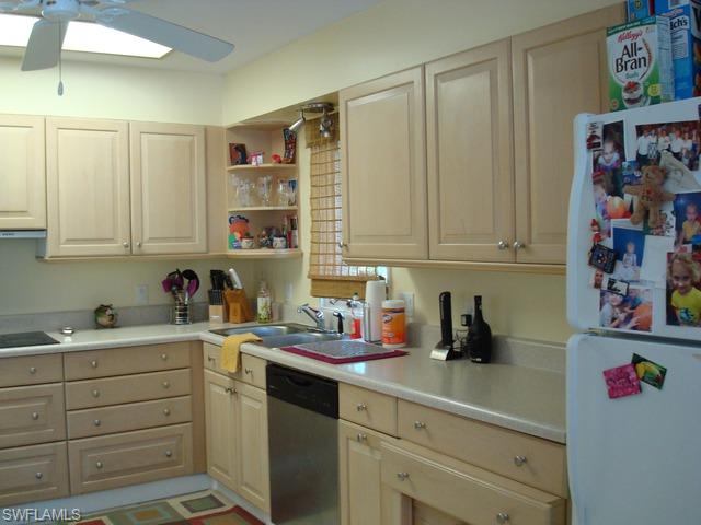 1205 Creech Road Naples, FL 34103 - Photo 6 of 10 a kitchen with cabinets appliances and a sink