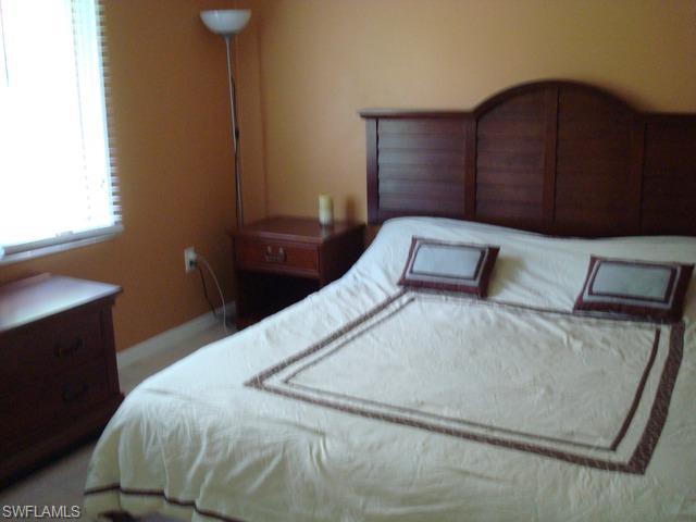 1205 Creech Road Naples, FL 34103 - Photo 8 of 10 a bedroom with a bed and a night stand