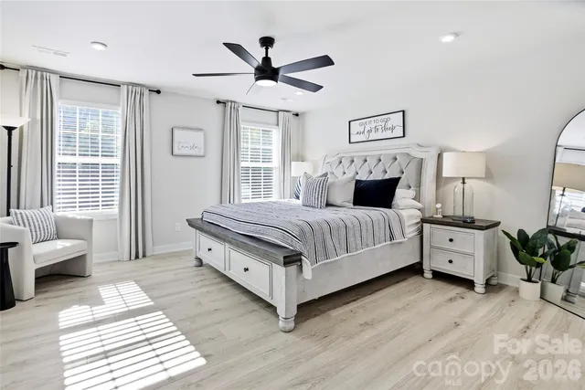 a bedroom with a large bed and wooden floor